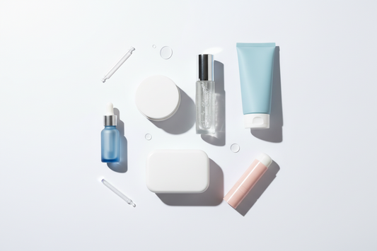    Neutrales Skincare‑Flatlay mit unbeschrifteten Creme‑Tiegeln, Serum‑Flakons, Pads‑Container und Cleanser‑Tube auf weißem Hintergrund, minimalistisch und klinisch‑sauber arrangiert.